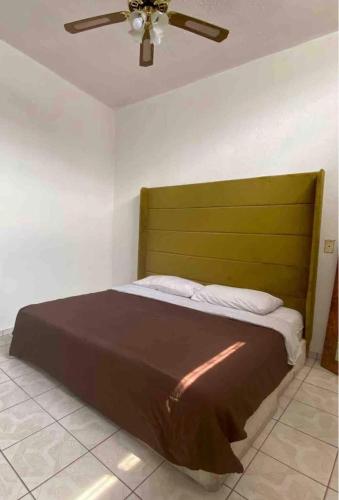 a bed in a room with a ceiling fan at Maison Carmona - Departamento Privado Económico - Centro Histórico in San Luis Potosí