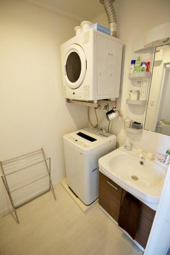 a bathroom with a washing machine and a sink at Vent du Vent302 in Minatogawa