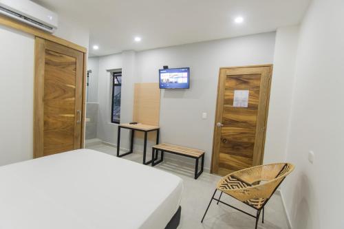 a bedroom with a bed and a tv on a wall at Stanza Hotel Sincelejo in Sincelejo