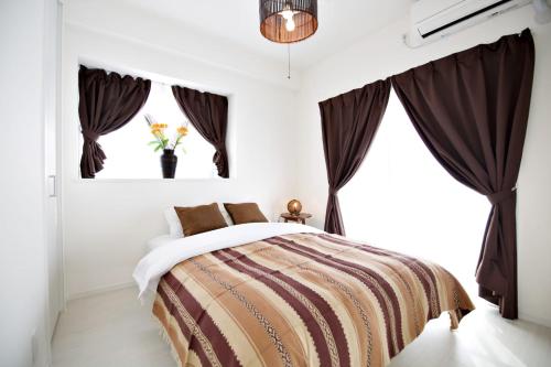 a bedroom with a bed with brown curtains at Vent du Vent302 in Minatogawa
