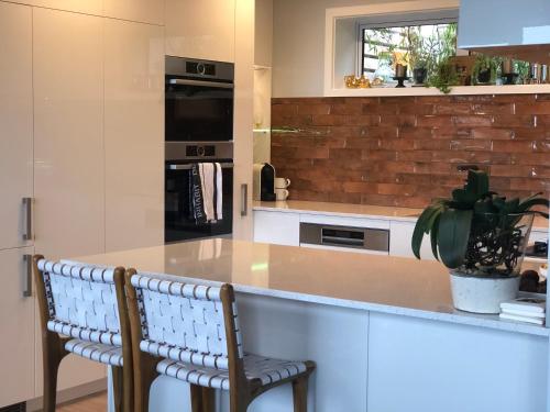 a kitchen with a counter and two chairs in it at Executive style bedroom in Kelburn