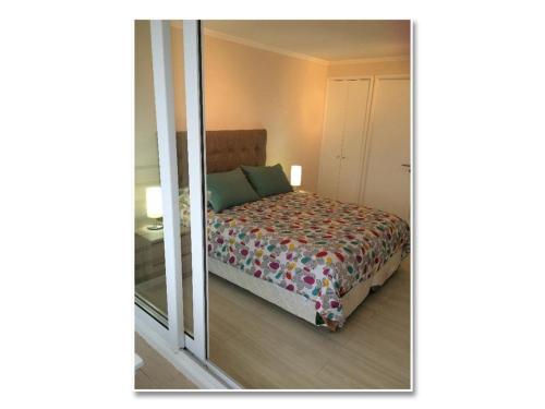 Apartamento Concon - Costas del Mar في فينيا ديل مار: غرفة نوم بسرير ومرآة