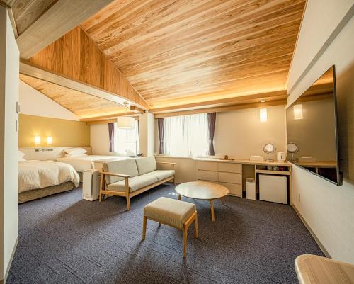 倉敷市にある倉敷アイビースクエアのベッド2台とリビングルームが備わるホテルルームです。