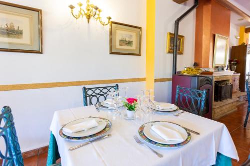 a table with a white table cloth and plates on it at Hotel Rural Serrella in Castell de Castells