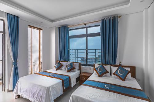 2 camas en una habitación con ventana grande en Blue Moon Tam Đảo en Sơn Ðình
