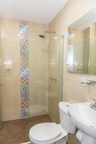 a bathroom with a toilet and a shower and a sink at Casa Caribe Colonial in Barranquilla