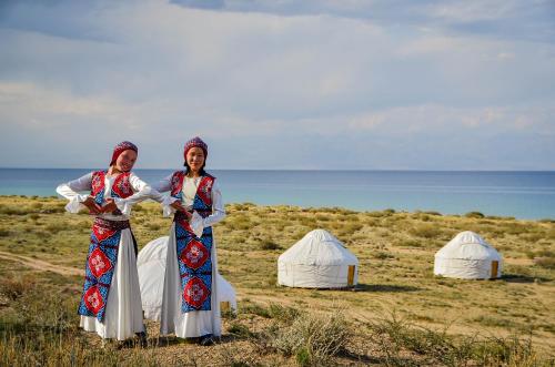 two women standing in front of tents in a field at Feel Nomad Yurt Camp in Ak-Say