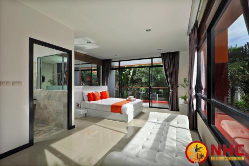 a bedroom with a white bed and a large window at Nai Harn Condominium in Nai Harn Beach