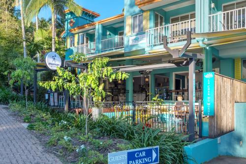 a building with a cafe on the side of it at Le Cher Du Monde Adults Only in Port Douglas
