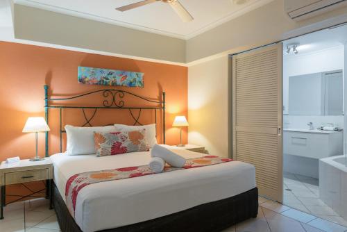 een slaapkamer met een bed met een laptop erop bij Le Cher Du Monde Adults Only in Port Douglas