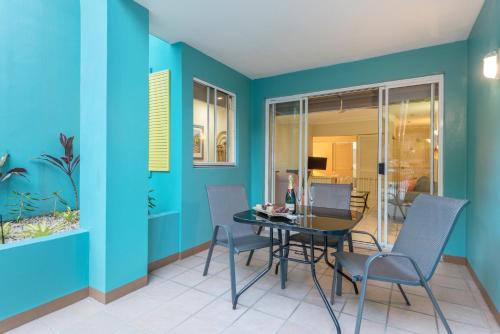 a dining room with blue walls and a table and chairs at Le Cher Du Monde Adults Only in Port Douglas