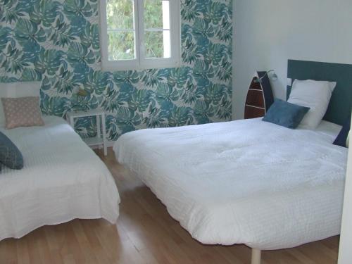 a bedroom with two beds and a window at Gîte les Hortensias in Beauquesne