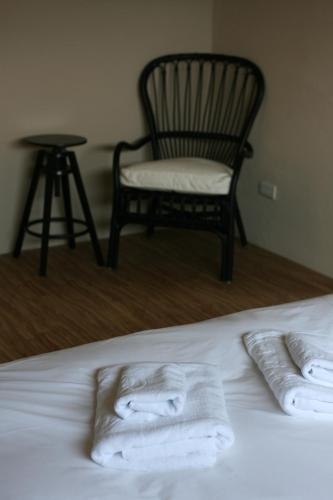 a bed with two towels on it with a chair at Seashore My Home in Eluan