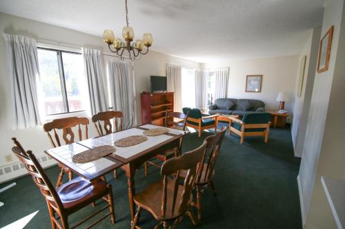 a dining room and living room with a table and chairs at Bighorn Inn & Suites in Canmore