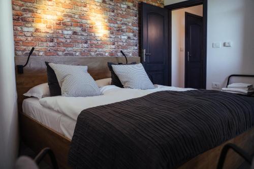a bedroom with a large bed with a brick wall at Bužinel Estate in Dobrovo