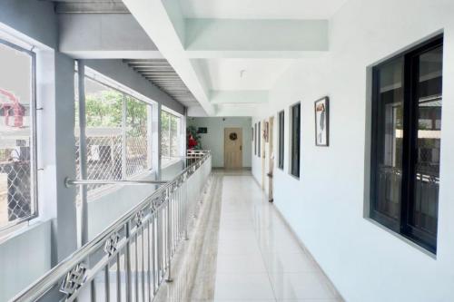 a corridor of a building with white walls and windows at Patricios Apartelle Taguig in Manila