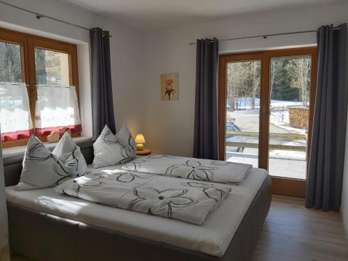 - un grand lit dans une chambre avec une grande fenêtre dans l'établissement Ferienwohnung Innerbichler, à Ellmau