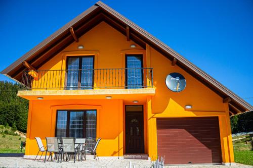 une maison orange avec une table et des chaises devant elle dans l'établissement Holiday Home Lisica, à Žabljak