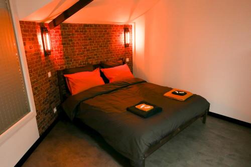 a bed in a room with a brick wall at Meublé de tourisme 3 étoiles Loft industriel à Fismes in Fismes