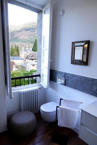 a bathroom with a toilet and a large window at Maison Eugénie in Luchon