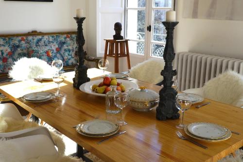 a wooden table with a plate of fruit and wine glasses at Maison Eugénie in Luchon