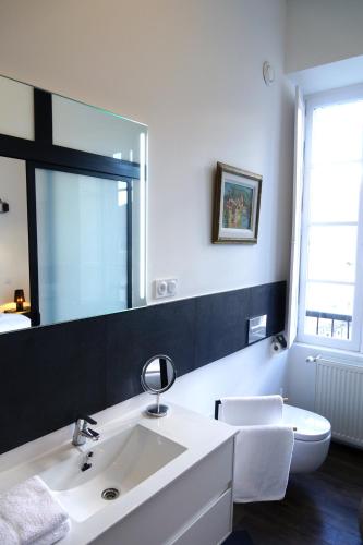 a bathroom with a white sink and a mirror at Maison Eugénie in Luchon