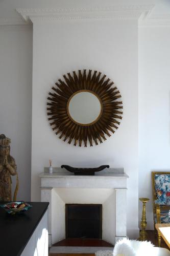 a living room with a mirror over a fireplace at Maison Eugénie in Luchon