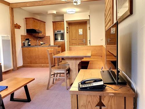 Una cocina con una mesa de madera y un comedor. en Arc 1950, en Arc 1950