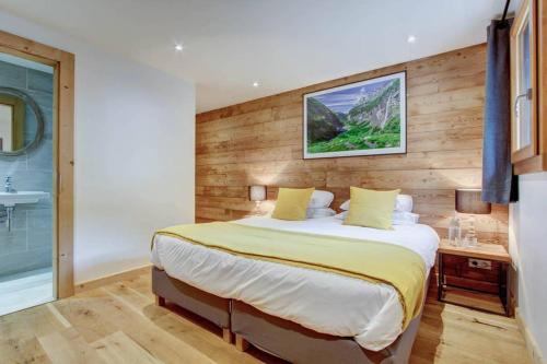 a bedroom with a large bed and a bathroom at Chalet La Petite Grange in Morzine