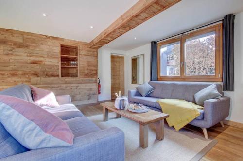 a living room with two blue couches and a table at Chalet La Petite Grange in Morzine