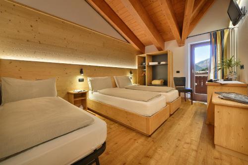 um quarto com 2 camas e uma janela em Hotel San Giovanni em Livigno