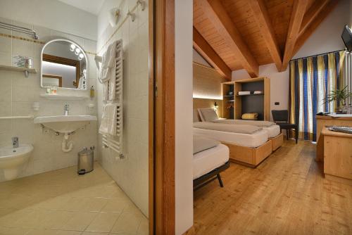 łazienka z 2 łóżkami i umywalką w obiekcie Hotel San Giovanni w Livigno