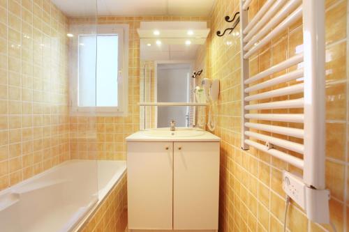 a bathroom with a sink and a bath tub at Résidence Odalys La Licorne de Haute Provence in Gréoux-les-Bains