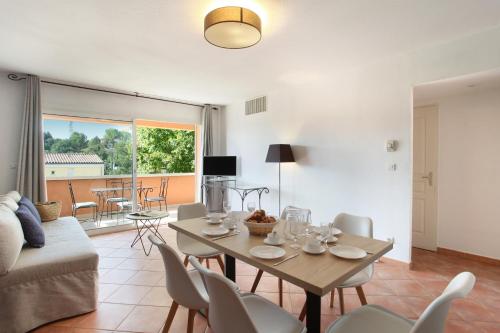 a living room with a table and chairs and a couch at Résidence Odalys La Licorne de Haute Provence in Gréoux-les-Bains