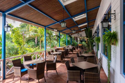 un patio al aire libre con mesas, sillas y árboles en La Siesta Salou Resort & Camping, en Salou