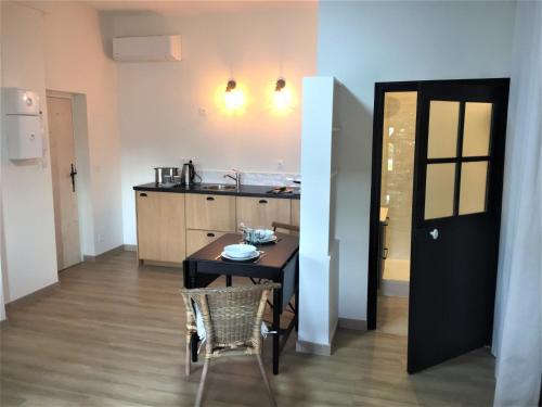 a kitchen with a table and chairs in a room at Carnets de voyage Coté studios in Lorgues