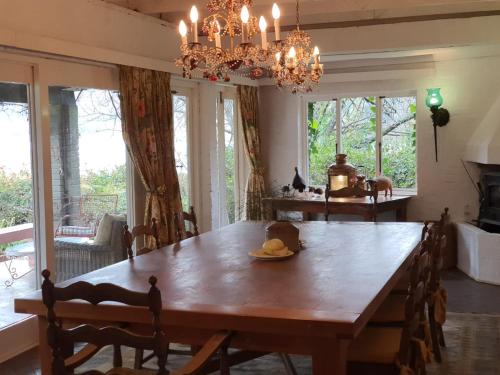 a dining room with a wooden table and a chandelier at Beacon Vlei Guest farm in Balgowan