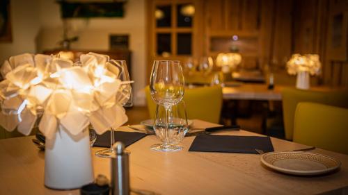 a table with a wine glass and a vase on it at Le Bonheur dans le Pré in Lucinges