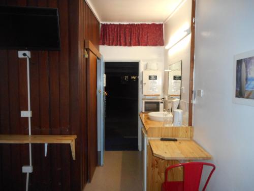 a kitchen with a refrigerator, sink, and stove at Nationwide Motel in Gympie