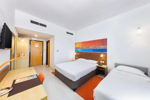 فندق سيتي ماكس بر دبي في دبي: غرفة فندقية بسريرين ومكتب