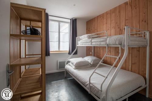 a bedroom with two bunk beds and a window at Gîte de Granit ROSE in Besse-et-Saint-Anastaise