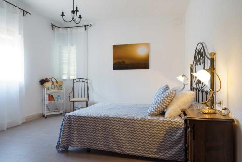 une chambre avec un lit, une lampe et une chaise dans l'établissement Loma Méndez Casa 2, à Casarabonela