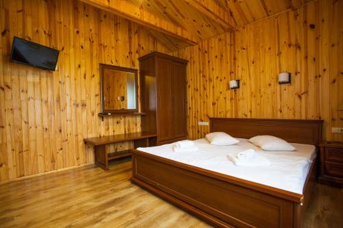 una camera da letto con letto in una camera in legno di Park Rost Club a Zadonetskoye