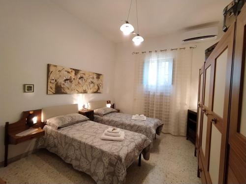 a bedroom with two beds and a window at Dedo B&B in Terlizzi