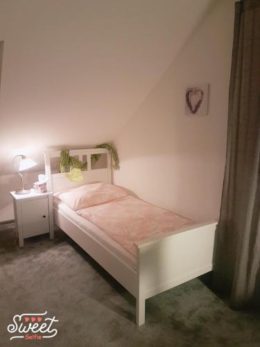 a bedroom with a white bed and a night stand at Ubytování U Špačků Pálava in Novosedly
