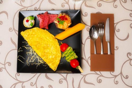 a black plate with food on a table at Curtea Bizantina in Suceava
