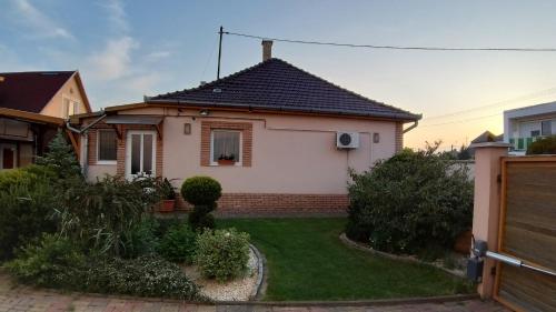 mały biały dom z ogródkiem w obiekcie Édenkert Apartmanház w mieście Kisvárda