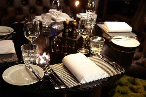a black table with wine glasses and napkins on it at Malmaison Dundee in Dundee