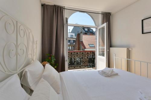 
a white bed sitting in front of a window at Villa Olga in Blankenberge
