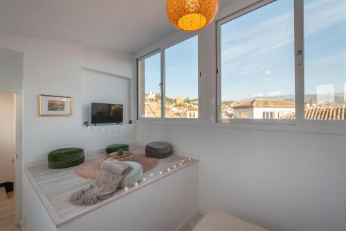 un soggiorno con una grande finestra e una TV di MOLINO CORTEZA DELUXE 6 pax a Granada